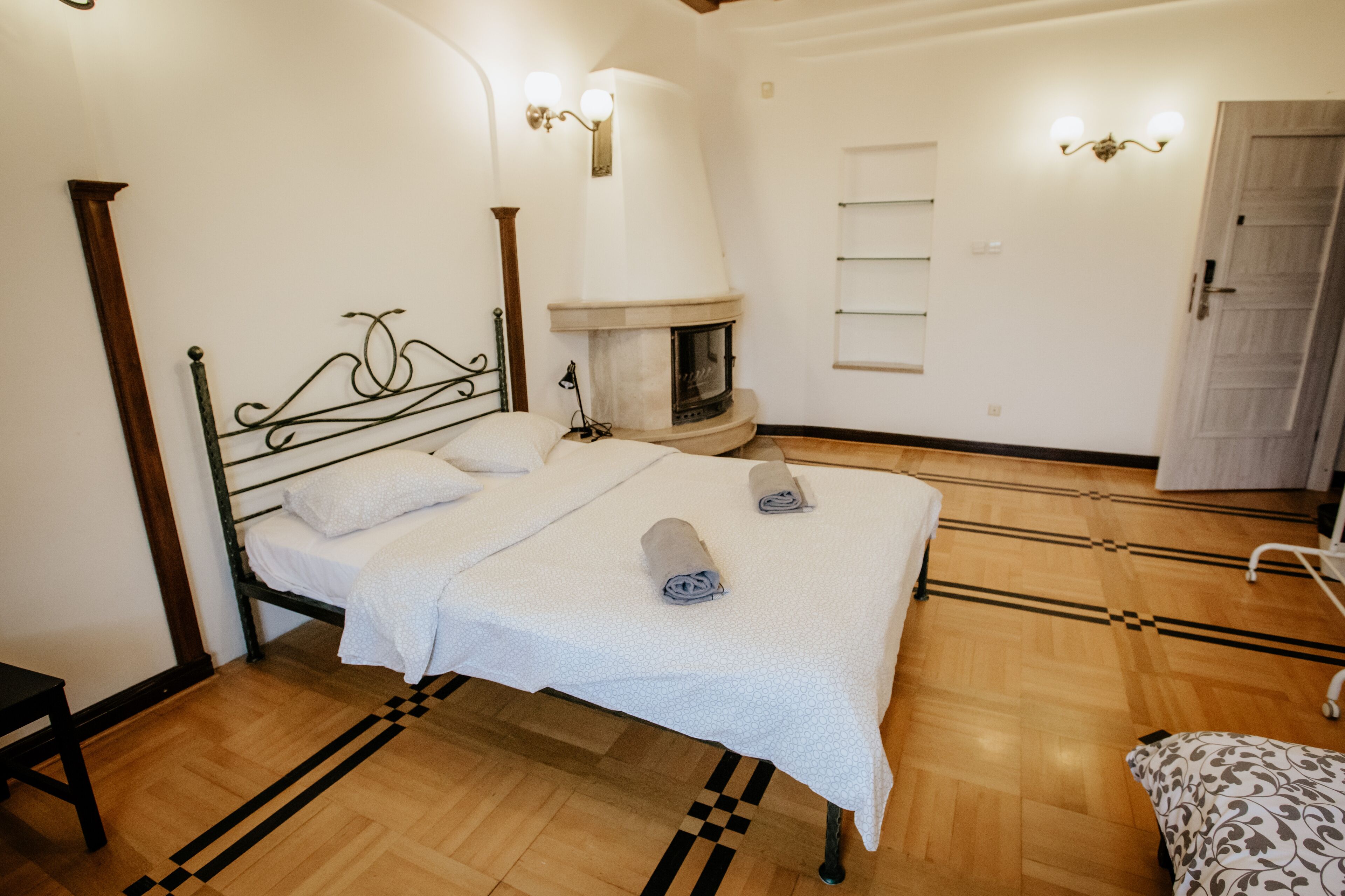 Ein Schlafzimmer mit einem Bett, einem Kamin und Holzboden.