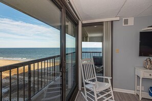 Ein Balkon mit Blick auf Strand und Meer.