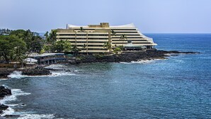 Un hotel de diseño moderno situado en una costa rocosa con vistas al océano.