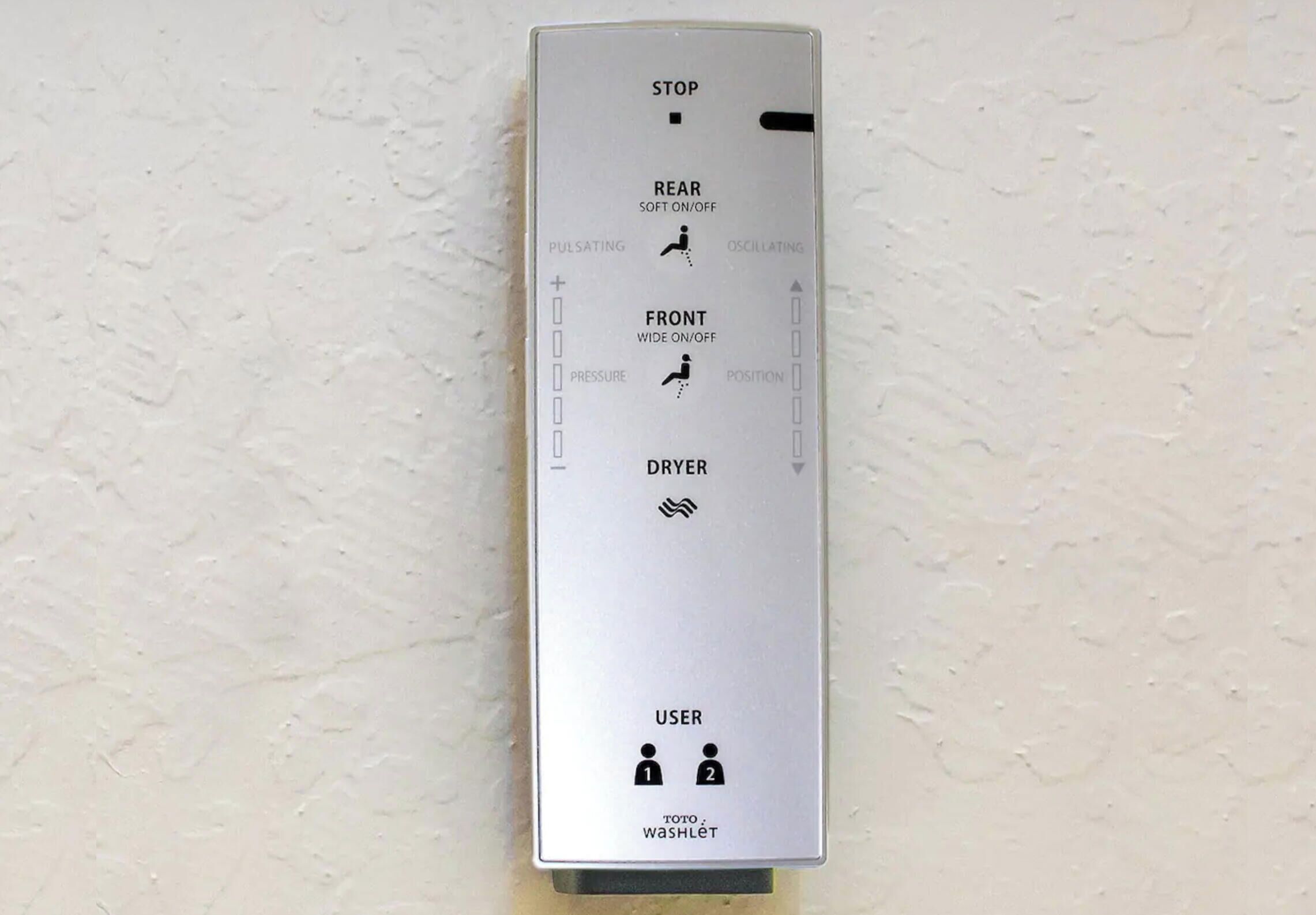A TOTO Washlet C200 wall-mounted bidet with control panel features including stop, rear soft on/off, pulsating, oscillating, front wide on/off, pressure, position, and dryer.