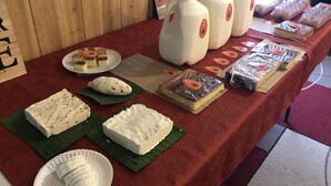 A table with various food items, including cakes and pastries, on a red tablecloth.