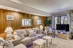 Relax in this stylish living room with a comfortable sofa set, armchair, and flat-screen TV.