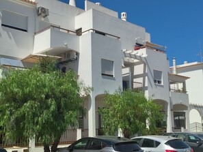 A multi-story building with balconies, air conditioning units, and a clear blue sky. - Apartment, with pool, near the beach (Albufeira)
