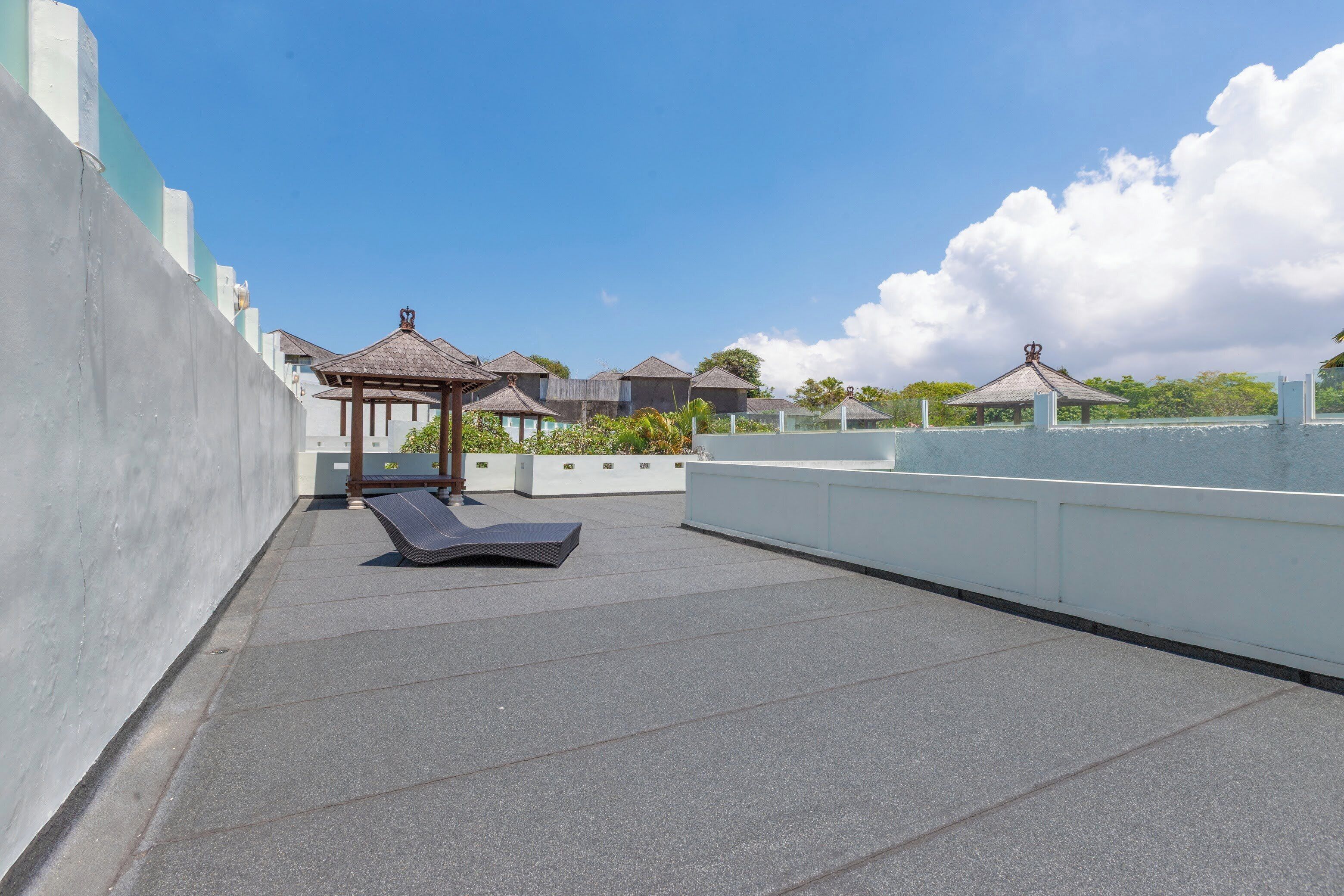Une terrasse sur le toit, dotée de chaises longues, d’une pergola et offrant une vue sur la mer.