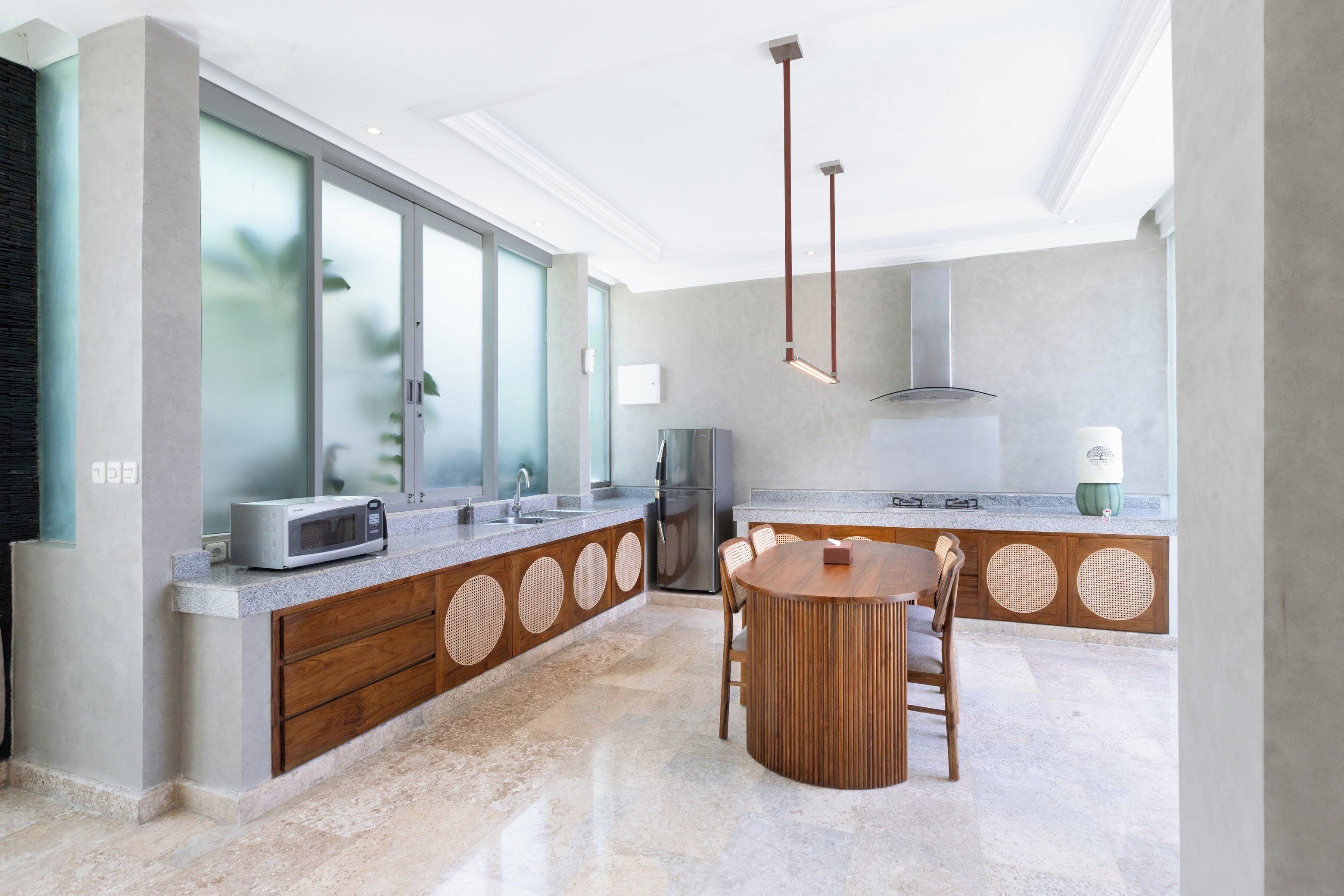 Una cocina moderna con una isla central, electrodomésticos integrados y un ventanal amplio.
