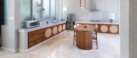 Una cocina moderna con una isla central, electrodomésticos integrados y un ventanal amplio.