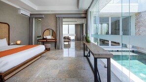 Una habitación de hotel moderna con una cama grande, un escritorio, una silla, un sofá y un balcón acristalado con piscina.