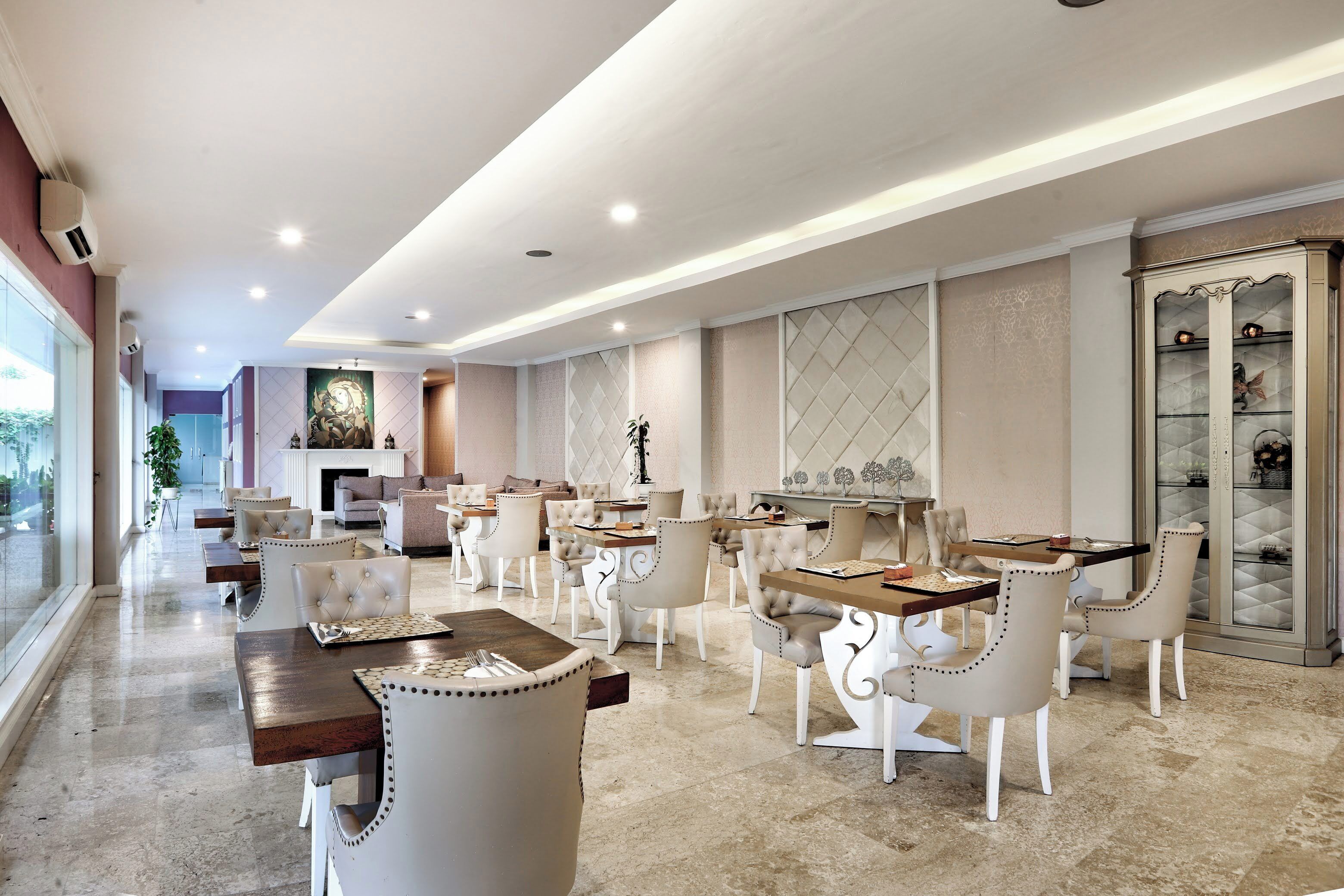 Un amplio vestíbulo de hotel con varias zonas de restauración, asientos cómodos y un gran aparador decorativo.