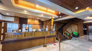 A reception area with a wooden counter, a staircase, and a glass display case.
