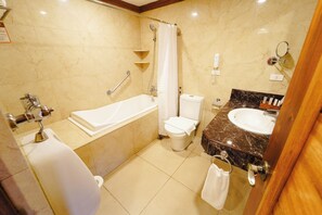 A bathroom with a bathtub, toilet, sink, and shower. - Sol Y Viento Hotel and Resort (Calamba)