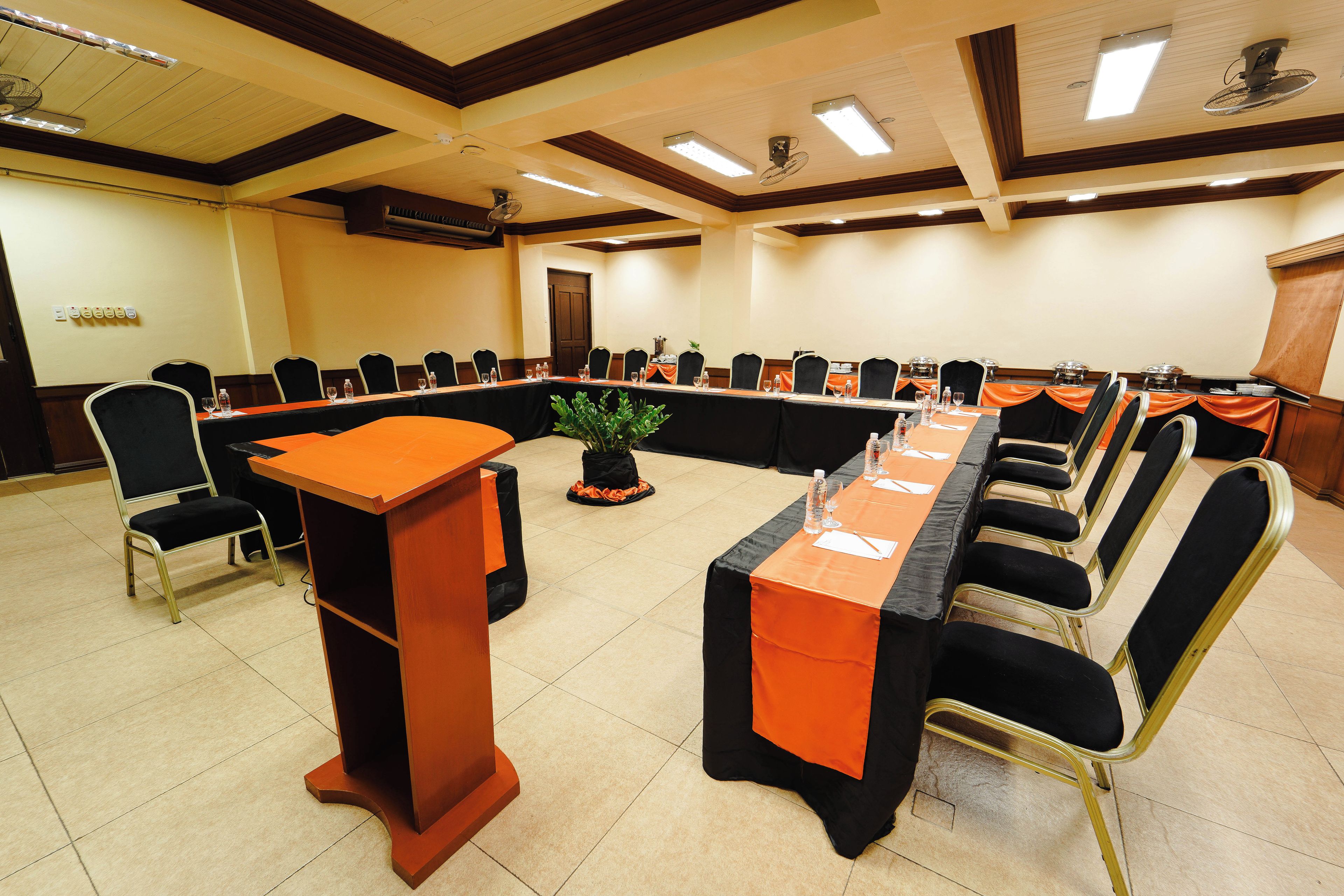 A conference room with a long table, chairs, and a podium.