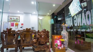 Eine Hotelhalle mit aufwendigen Holzmöbeln und einer großen Vase mit Blumen.