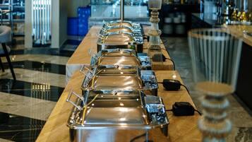 A buffet setup with multiple serving stations and a central decorative light fixture.