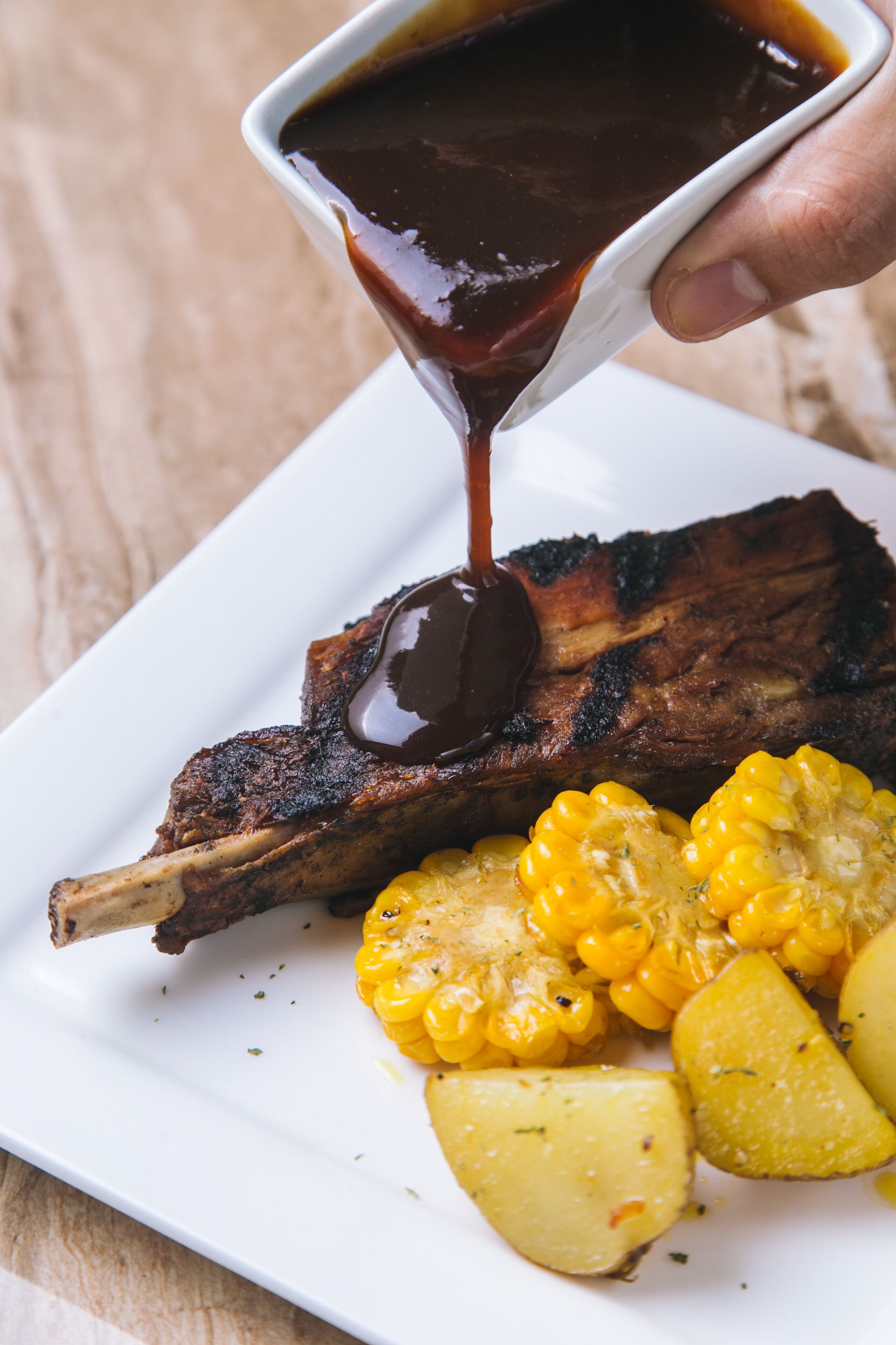 Une assiette de viande grillée, de maïs et de pommes de terre.