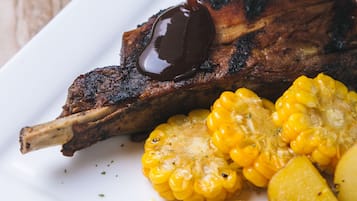 Une assiette de viande grillée, de maïs et de pommes de terre.