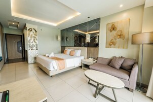 Una habitación de hotel moderna con una cama, un sofá, una mesa y una lámpara.