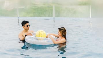Una parella en una piscina amb un joguet aquàtic.