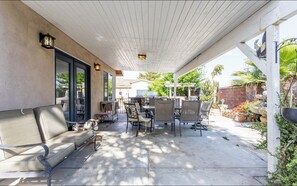 An outdoor patio with a covered seating area, a grill, and a stone wall. - Heart of LA Large single level pool BBQ home (Chino)