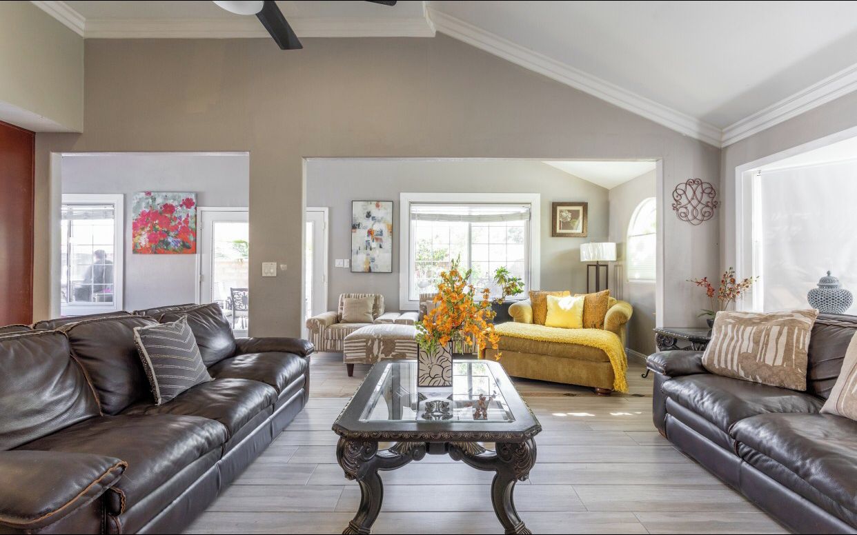 A spacious living room with a high ceiling, a central coffee table, and two sofas.