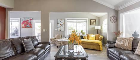 A spacious living room with a high ceiling, a central coffee table, and two sofas.