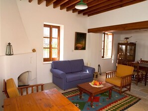 Relax in this inviting living room with a blue-striped sofa, wooden coffee table, and a comfortable armchair.