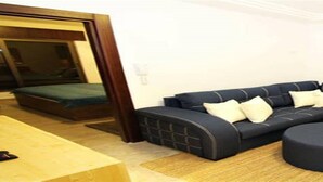 Una sala moderna con un sofá modular, un taburete redondo y una pequeña mesa.