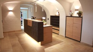 Un área de recepción con mostrador de madera, techo abovedado y suelo de baldosas.