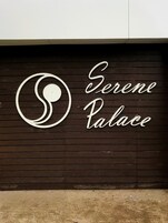 Un letrero con el texto 'Serene Palace' y un logo estilizado.
