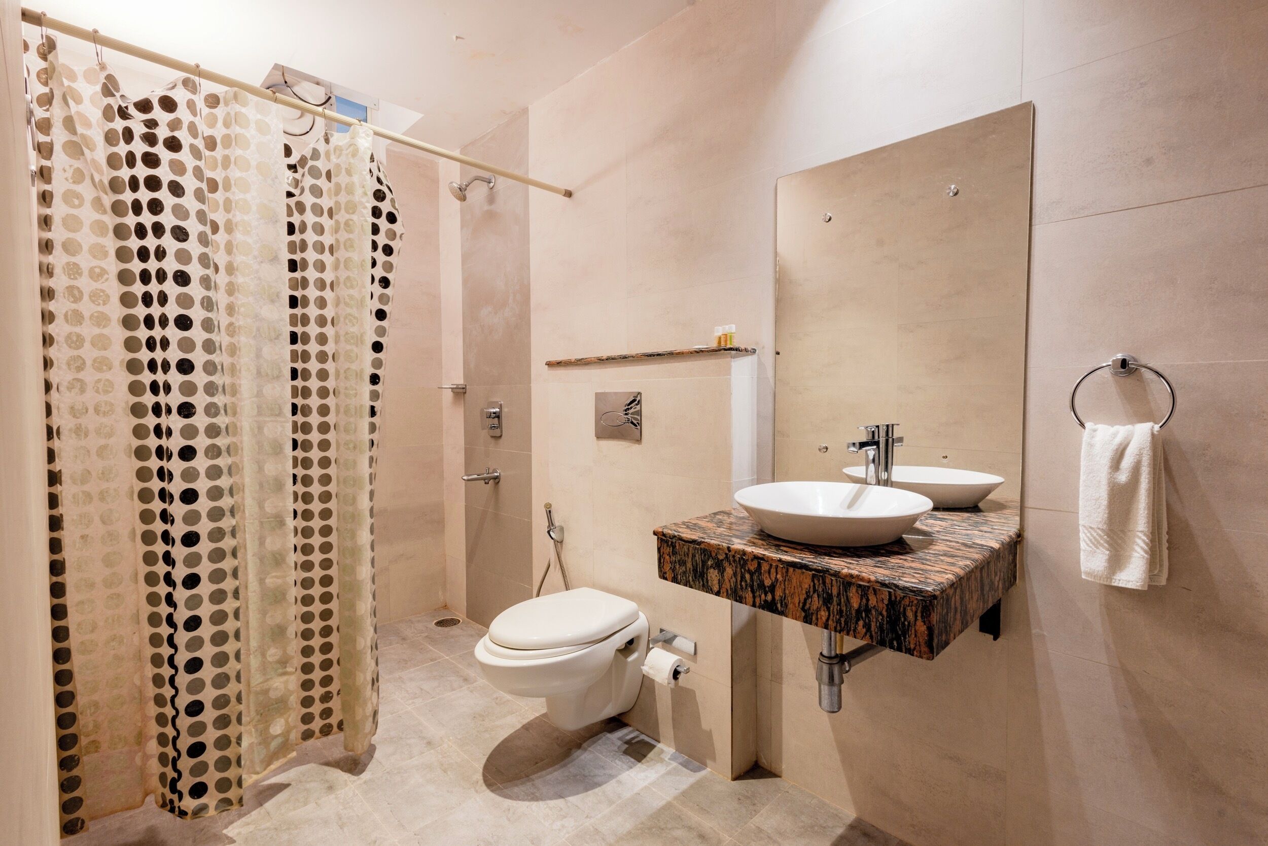A modern bathroom with a toilet, sink, and shower curtain.