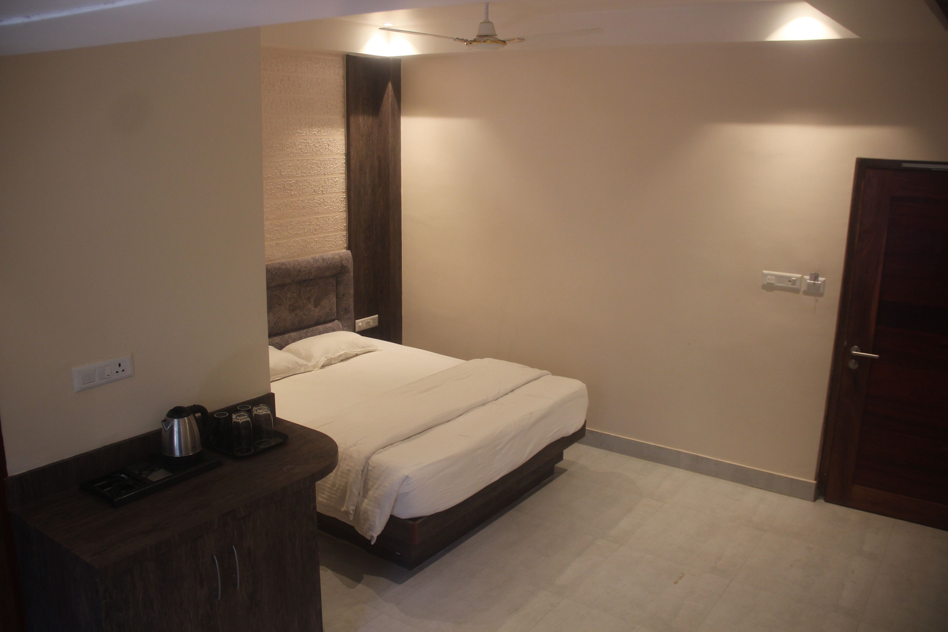 A bedroom with a bed, bedside table, and a ceiling fan.
