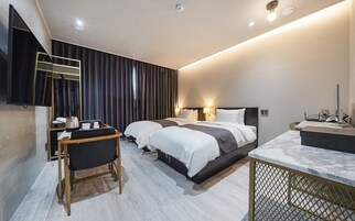 Una habitación de hotel moderna con una cama grande, un escritorio y un televisor.