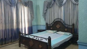 Ein Schlafzimmer mit einem hölzernen Bett, zwei Nachttischen und Vorhängen.