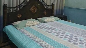 Ein Schlafzimmer mit Bett, Vorhängen und Nachttisch.