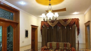 Ein Zimmer mit einer Chandelüster, einem Sofa und Vorhängen.