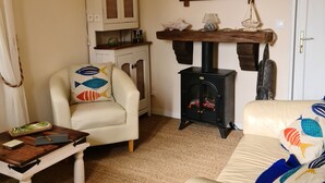 A cozy living room with a white sofa, a wooden coffee table, a white cabinet, a fireplace, and a mirror on the wall. - Lake view Lodge chambon Eguzon  <br>Beautiful  Lake Views  (Éguzon-Chantôme)