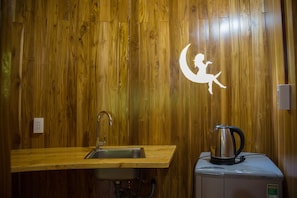 A wooden interior with a sink and a kettle on a small appliance. - Valley Sen Bungalow (Phu Quoc)