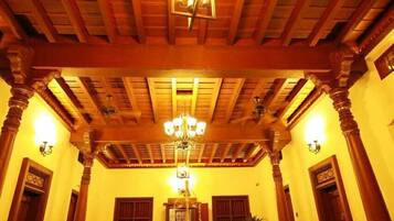 A spacious lobby with wooden beams, a chandelier, and traditional decor.