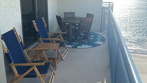 A balcony with a table and chairs, a view of the ocean, and a railing. - Brighton towers.Stay were the view is Beautiful.2 miles to Tanger Outlets!! (Myrtle Beach)