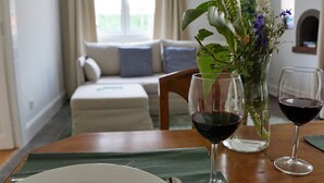 Une table à manger avec deux verres à vin et un vase de fleurs.