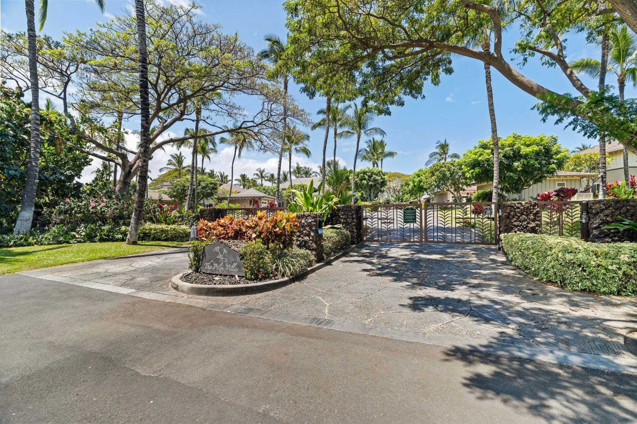 A gated entrance to a property with a stone pathway leading to a gate.