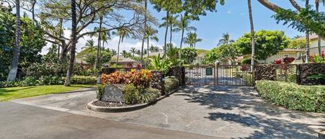 A gated entrance to a property with a stone pathway leading to a gate.