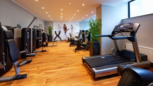 A gym with cardio equipment, weight machines, and a treadmill. - Stadthotel Borken by Hackmann (Borken)