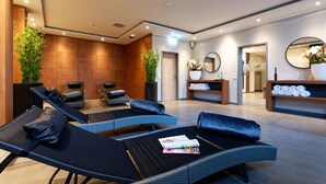 A modern spa area with lounge chairs, a reception desk, and a mirror. - Stadthotel Borken by Hackmann (Borken)