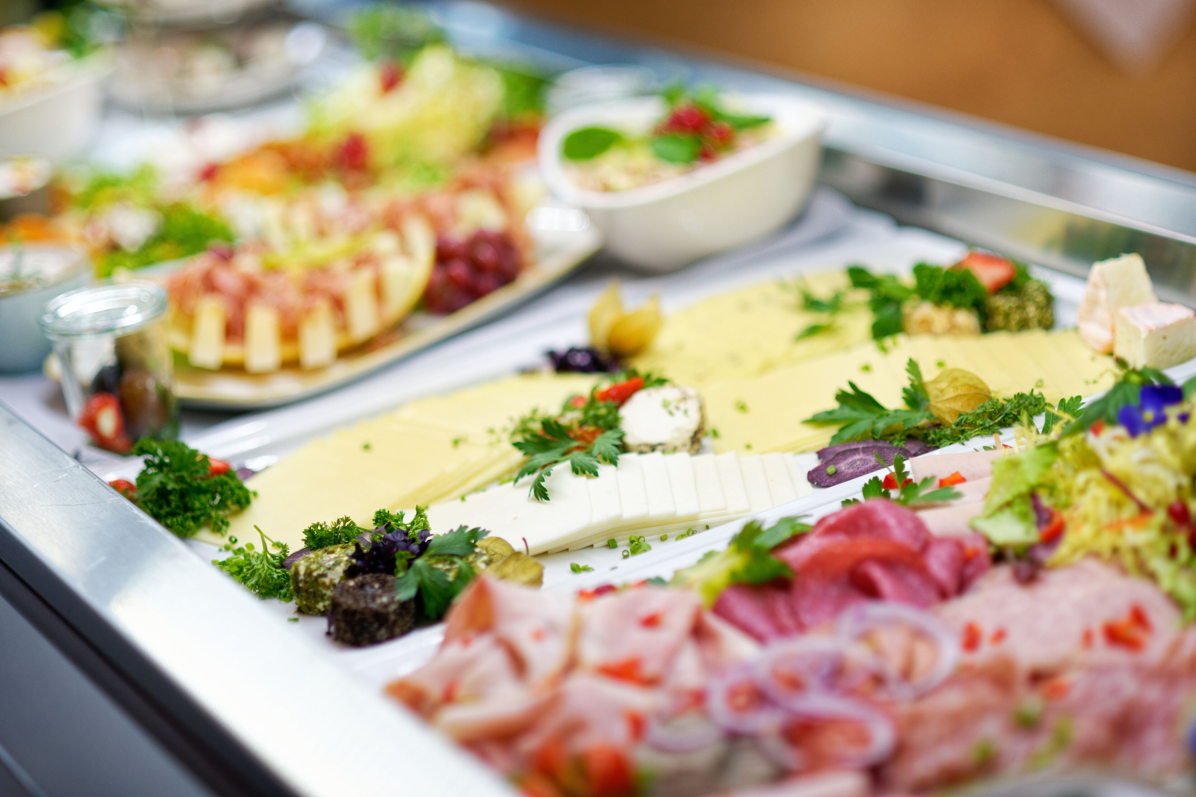Ein reichhaltiges Buffet mit verschiedenen Speisen, darunter Käse, Fleisch und Beilagen.