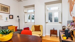 Una sala de estar moderna con sofá, sillones, una mesa de comedor y un ventanal grande.