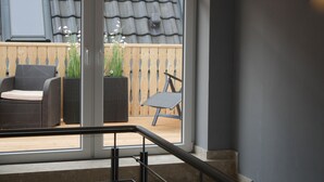 A modern interior with a staircase leading to a balcony. - Hotel Garni Thule (Wittmund)