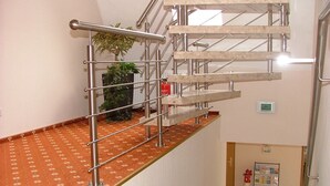 A staircase with metal railings and a red carpeted landing area. - Hotel Garni Thule (Wittmund)