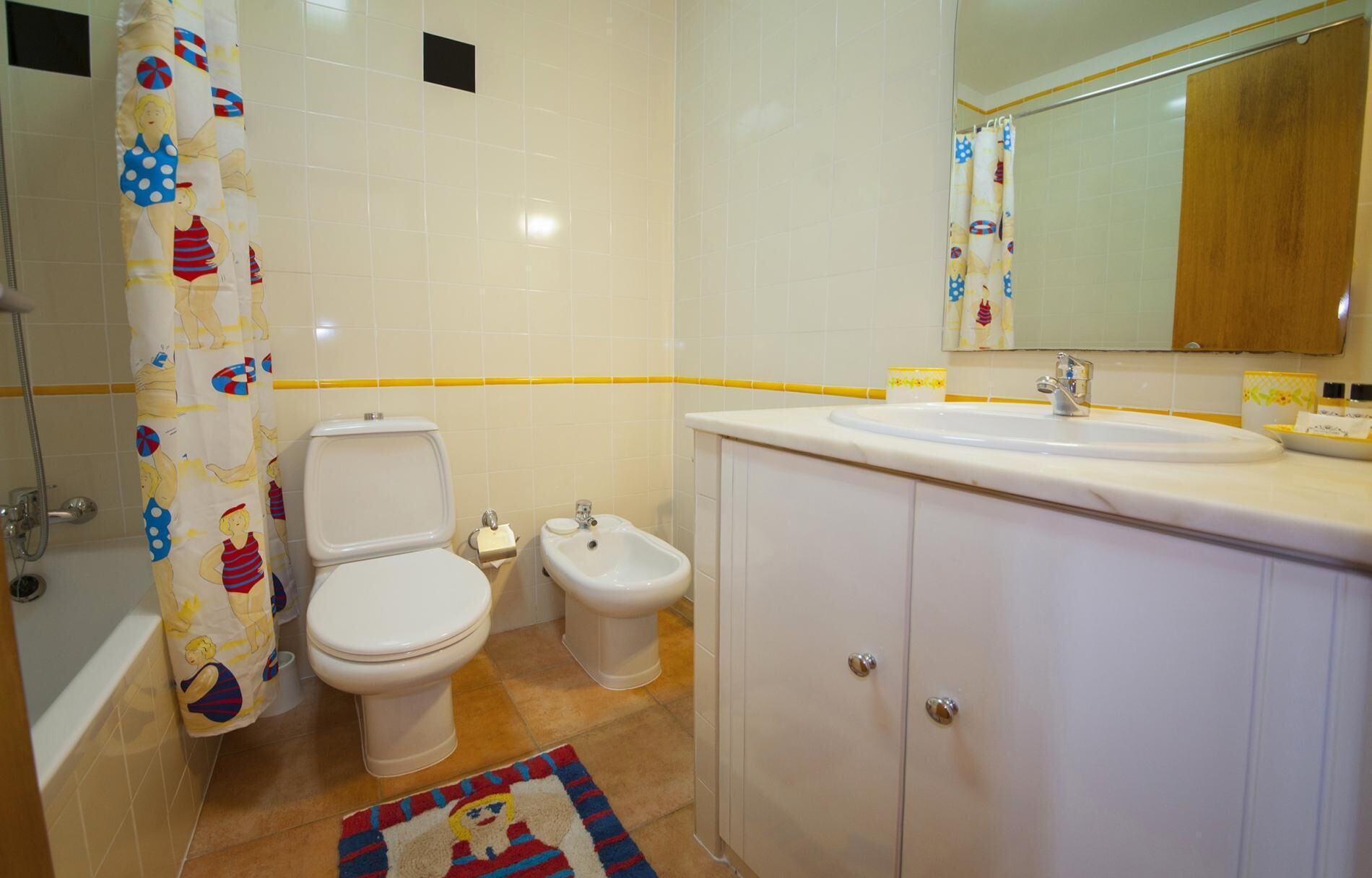 Une salle de bain équipée de toilettes, d’un bidet et d’un lavabo.