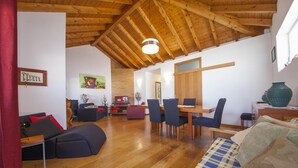 A spacious living area with a wooden ceiling, a dining table with chairs, and a sofa. - A33 - Fishermans Cottage in Lagos (Lagos)