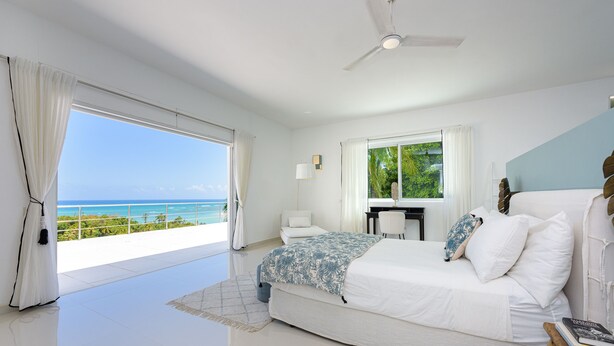 A bedroom with a bed, a desk, and a view of the ocean. - Fabulous Experience AC, Gym, Chef and Staff Available  (Las Terrenas)